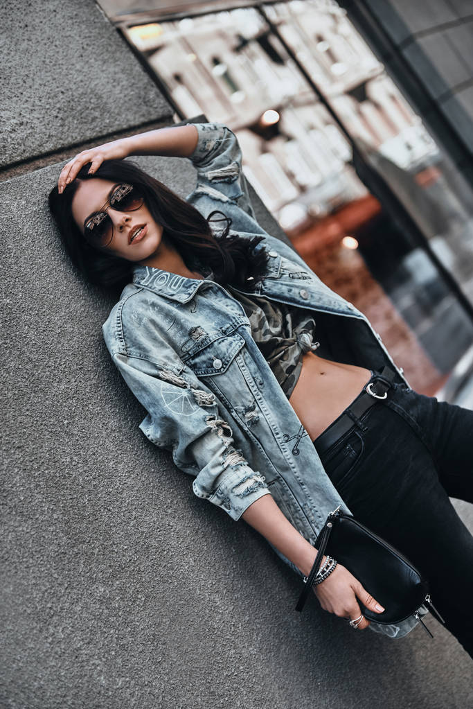 时尚的女人，靠着墙