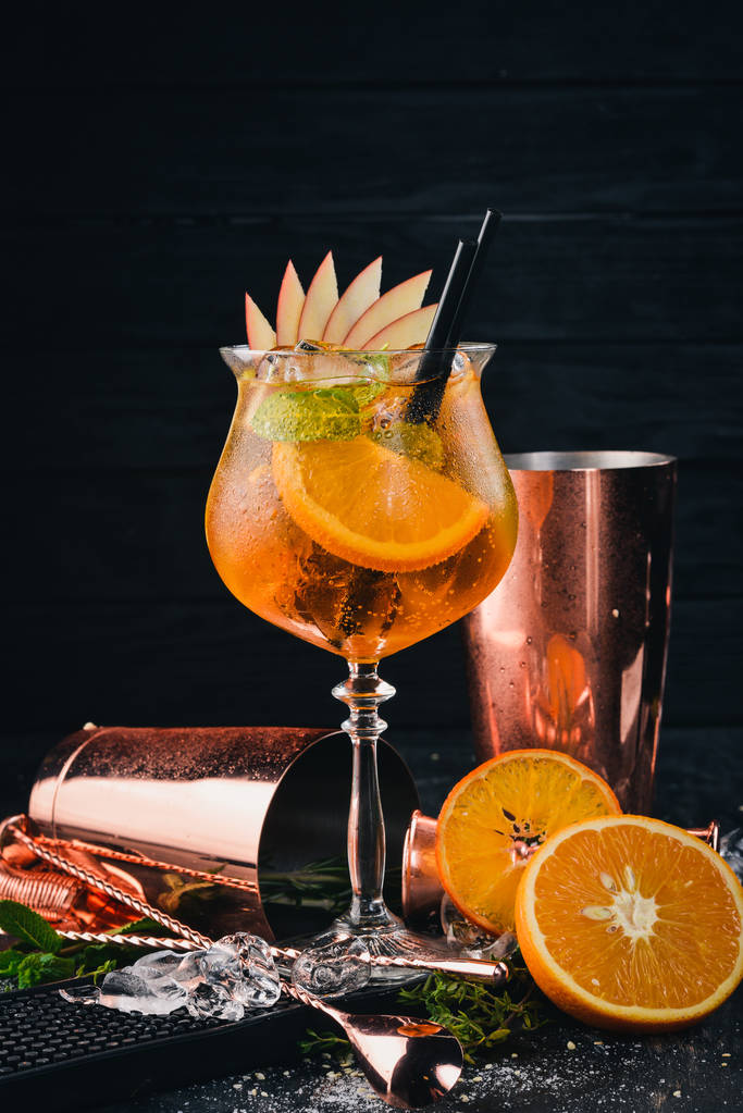 酒吧里有酒精鸡尾酒 Aperol。橙色.在黑色的木质背景上.